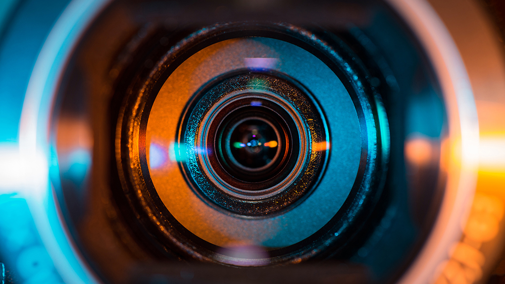 Video camera lens lit in blue and orange